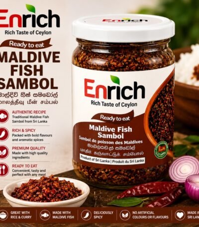 A jar of Enrich Maldive Fish Sambol next to a bowl of the sambol, fresh onions, dried chilies, and a lime wedge.